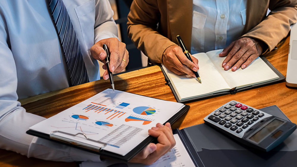 Business bookkeeping with calculator of bookkeeper and household calculating chart graph annual financial account.