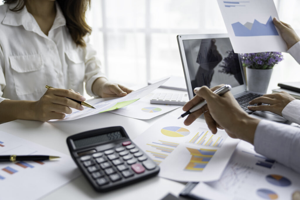 A close-up of hands working on a laptop with financial charts and graphs on the screen, symbolizing professional accounting and bookkeeping services.